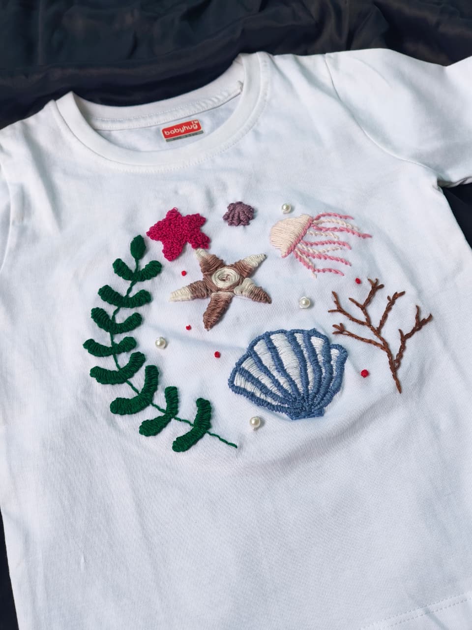 Hand embroidered kids white t-shirt with ocean and beach theme design.