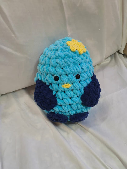 Sky handmade crochet duck plush made with ultra-soft premium blanket yarn in bright blue with flower detail.