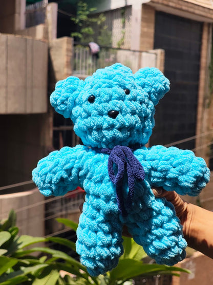 Cute handmade crochet teddy bear plush with a decorative bow, soft amigurumi stuffed toy for bedroom decor, baby gifts, and home decoration.