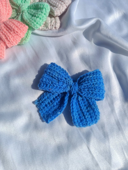 Four handcrafted crochet  hair clips in pink, blue, green, and orange colors